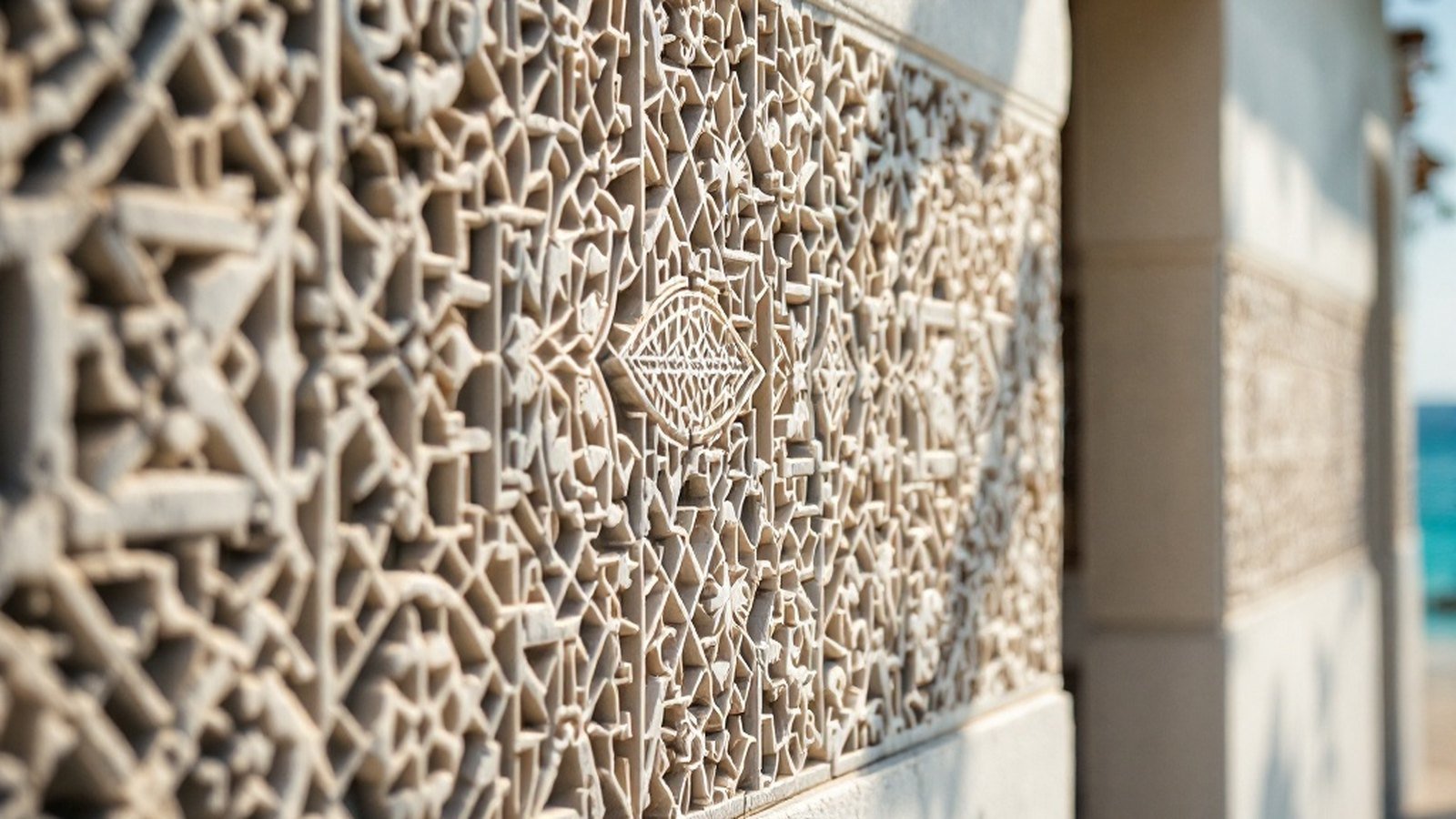 Close-up of carved geometric and calligraphic patterns on Hukuru Miskiy's exterior coral-stone wall