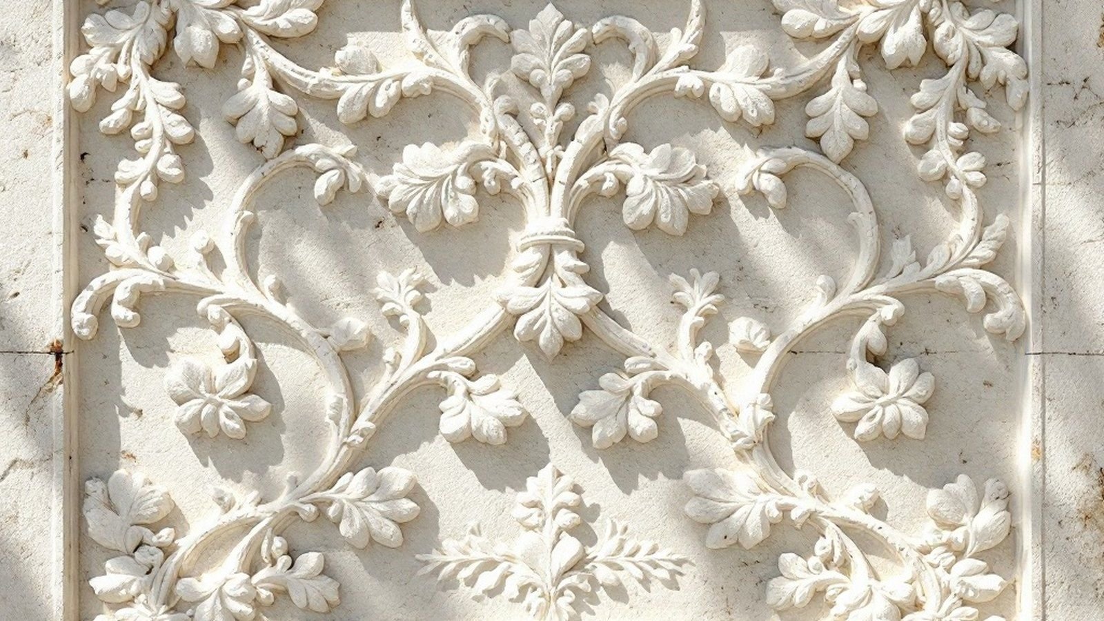 Exterior wall of Hukuru Miskiy showing coral-stone texture up close, carved interlocking panels of vines and rosettes