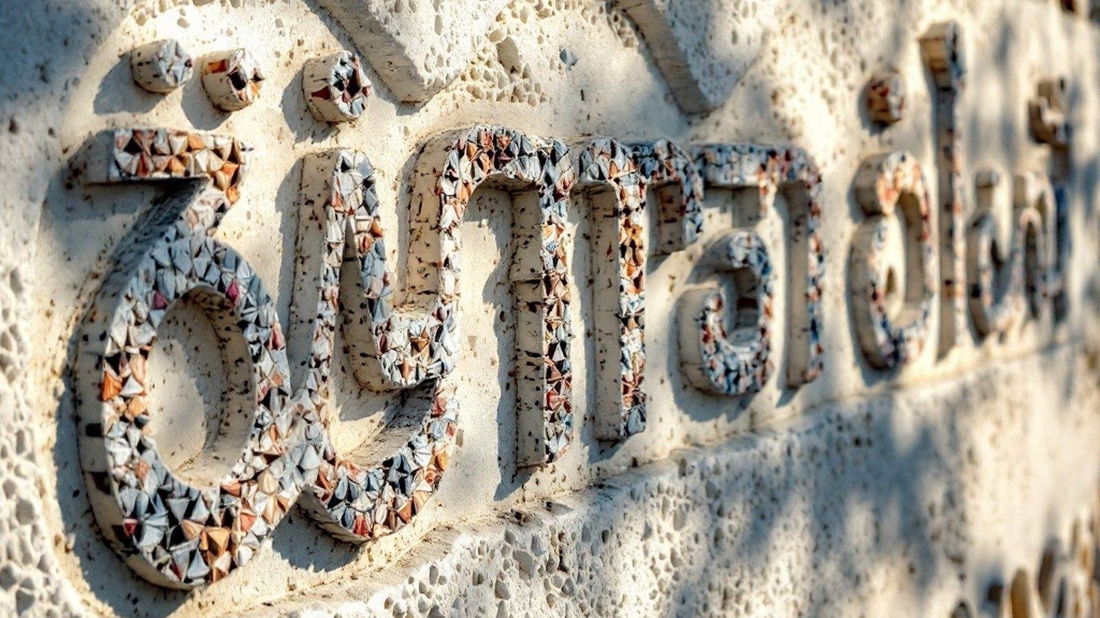 Close-up of Thaana letterforms on a mosque wall or carved stone inscription